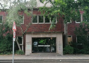 Aktuelles zur Diskussion um die Zukunft des ehemaligen Hallenbads in Herne-Eickel Ehemaliges Hallenbad Eickel in Herne aus rotem Klinker mit starkem Sanierungsbedarf in einer deutschen Innenstadt. Der Eingangsbereich ist von Graffiti verunstaltet, Bäume wachsen direkt an der Fassade. Das Gebäude wirkt verlassen und ungepflegt. Straßenschild mit Tempo-30-Zone im Vordergrund.