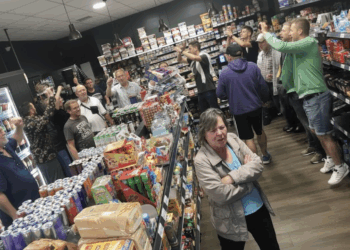 Innenansicht von Okis Kiosk an der Bahnhofstraße in Herne-Baukau: tanzende Personen, Ausschank und Konsum alkoholischer Getränke; DJ und SPD-Ratskandidat Alexander Stahl legt beim Buden-Rave auf.