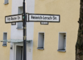 Heinrich Lersch Straße Herne: Graf Hotte hat Antrag auf Umbenennung eingereicht Straßenkreuzung Fritz-Reuter-Straße/Heinrich-Lersch-Straße in Herne Wanne-Eickel; Straßenschilder vor gelb-weißem Wohngebäude Nr. 18 und Baumstamm.