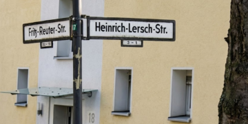 Straßenkreuzung Fritz-Reuter-Straße/Heinrich-Lersch-Straße in Herne Wanne-Eickel; Straßenschilder vor gelb-weißem Wohngebäude Nr. 18 und Baumstamm.