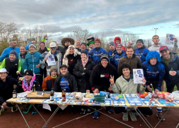 Bochumer Triathleten laufen Biermeile für Herner Hospizarbeit Fröhliche Laufgruppe des SV Blau-Weiß Bochum in bunten Kostümen feiert am Verpflegungsstand mit Snacks und Getränken nach einem Spaßlauf auf der Aschebahn.