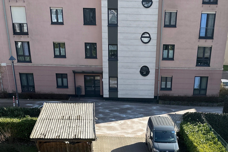 Wohngebäude der Herner Gesellschaft für Wohnungsbau mbH (HGW) mit Parkplatz und Fahrzeug.