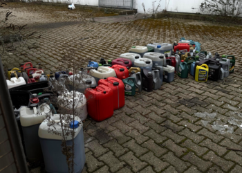 Reihe von Altöl-Kanistern auf dem Boden.