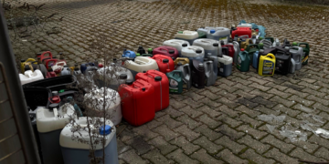 Reihe von Altöl-Kanistern auf dem Boden.