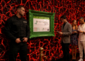 Sicherheitsbereich in einem Club mit Warteschlange, Security-Mitarbeiter und einem grün gerahmten Flucht- und Rettungsplan an einer rot beleuchteten Wand.