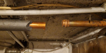 Offen getrennte Kupferrohrleitung unter einer Kellerdecke mit Dämmung, Leitungen, Kabeln und sichtbaren Verschmutzungen im Deckenbereich. In der Wiescherstraße 16 in Herne.