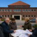 Altes Hallenbad Eickel in Herne mit Bürger:innen vor dem Gebäude bei der Prüfung von Unterlagen.