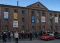 Mahnwache vor ehemaligem Gefängnisgebäude in Eickel mit bunten Bannern an vergitterten Fenstern für Hallenbad, Freiheit und Bürgerwillen.
