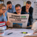 Besorgte Brandschutzplaner:innen lesen Zeitung zu geplanter BauO-NRW-Änderung und möglichen Folgen für freie Brandschutzbüros.