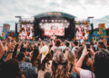 San Hejmo 2026 komplettiert sein Line-up Besucher:innen vor der farbenfrohen Mainstage des San Hejmo Festivals am Airport Weeze während eines Liveauftritts.