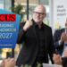 stefanbuddesiegel als Leading Innovator 2027 ausgezeichnet Mann im schwarzen Anzug und mit Brille steht in einem modernen Büro vor applaudierenden Kolleg:innen und hebt die Faust. Links ist das Logo „FOCUS Leading Innovator 2027“ eingeblendet.