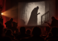 Nosferatu in Gladbeck: Stummfilm trifft Live-Musik im Maxus Zwei Musiker begleiten eine Stummfilmprojektion mit einer Vampirgestalt vor Publikum.