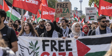 Demonstration mit Fahnen der Linken, palästinensischen Flaggen und Protestplakaten für Gaza in Berlin.