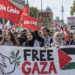 Muslimische Wähler:innen und Die Linke: Was Wahldaten wirklich sagen Demonstration mit Fahnen der Linken, palästinensischen Flaggen und Protestplakaten für Gaza in Berlin.