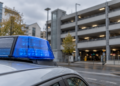 Staatsschutz ermittelt: Reichsflaggen und Banner in Dortmund Blaue Rundumleuchte auf einem Fahrzeug vor einem unscharf erkennbaren Parkhaus.