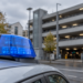 Staatsschutz ermittelt: Reichsflaggen und Banner in Dortmund Blaue Rundumleuchte auf einem Fahrzeug vor einem unscharf erkennbaren Parkhaus.