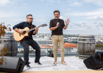 Thomas Anders berichtet von 30 Millionen neuen Streams Thomas Anders mit Mikrofon und ein Gitarrist auf einer Dachterrasse.