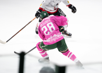 Eishockeyspieler in Aktion auf dem Eis in einer Eishalle