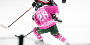 Eishockeyspieler in Aktion auf dem Eis in einer Eishalle