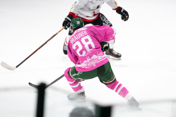 Eishockeyspieler in Aktion auf dem Eis in einer Eishalle
