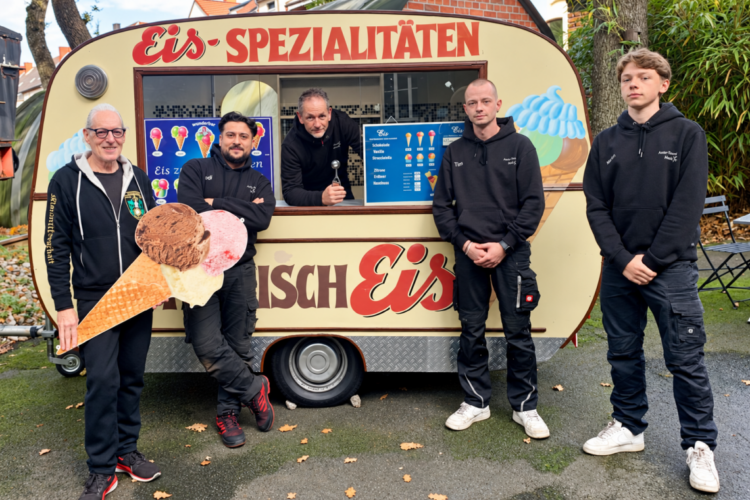 Hanisch-Eiswagen in Herne gerettet: Die Eiskugel ist zurück Fünf Personen stehen vor dem restaurierten historischen Hanisch-Eiswagen mit der Aufschrift Eis-Spezialitäten in Herne.